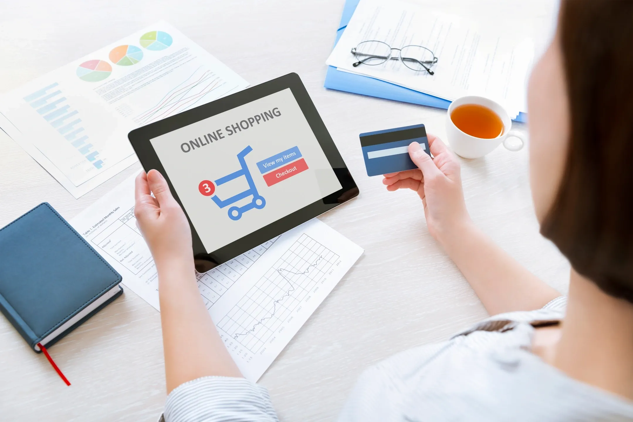 A person holding a tablet and credit card